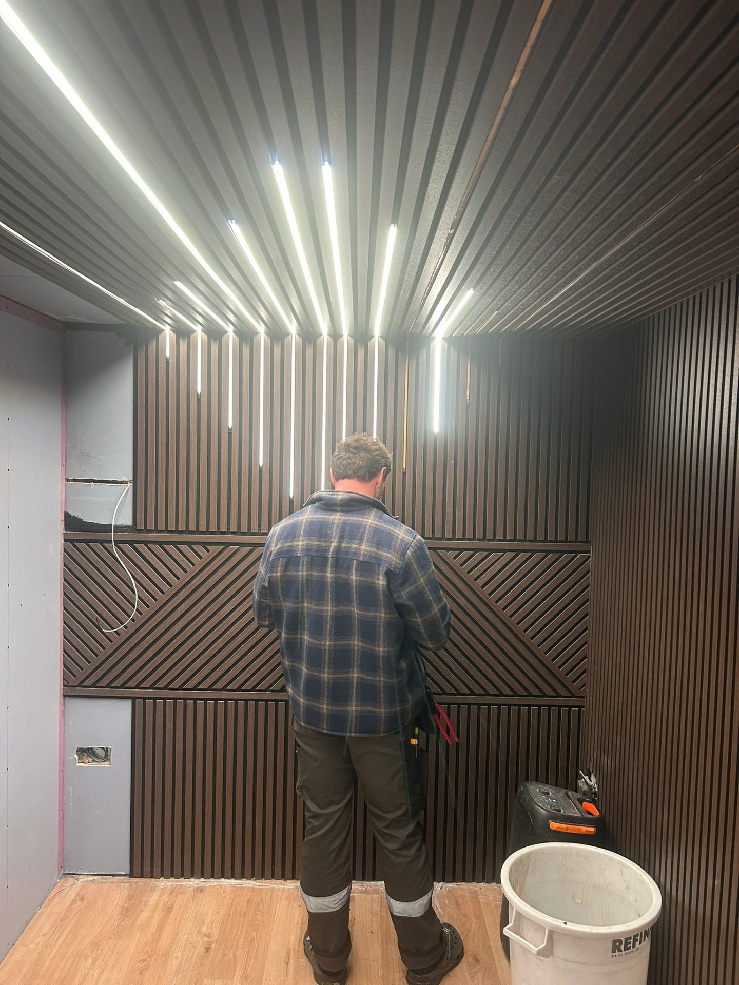 Henry installing a bespoke slatted feature wall with integrated LED lighting